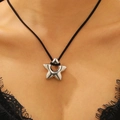 Gros plan d'un pendentif étoile argenté minimaliste sur un collier en cordon noir - Style Étoile Argent Miroir (A-956)
