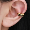 Gotische Ohrklemme mit drei Totenköpfen in Vintage-Gold-Optik für Ohren ohne Loch - Dreifach Totenkopf Ohrmanschette / Altgold