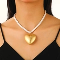 Close-up of chunky white rope necklace featuring a large matte gold heart pendant - Sand Gold