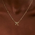 Goldene Schleifen-Halskette mit Perlenkette an dunkelhäutigem Modell mit Glanz - Minimalistische Schleife Perlenketten-Stil (G-545)