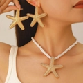 Goldenes Seestern-Schmuckset mit strukturierten Ohrringen und einer weißen Kordelkette - Seestern Halskette Ohrringe Set / Gold