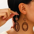 Detail showing deep brown wooden layers and metal hook of Bohemian dangle earrings - Wood Double Circle Drop Earrings (11909) / Dark Brown