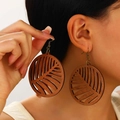 Detailed close-up of large bohemian wooden hoop earrings with palm leaf cutout pattern - Wood Hollow Leaf Drop Earrings (5036) / Dark Brown