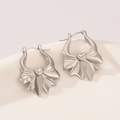 Silver bow earrings with heart center detail on white porcelain display stand - Bowknot Heart Hoop (0674) / Silver