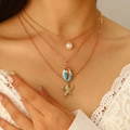 Dettaglio della collana a tre strati dorata con perla, pendente a conchiglia e stella marina - Stile Perla Conchiglia e Seppia (K-026)