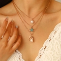 Dettaglio collana dorata a strati con perla, stella marina e ciondolo a conchiglia - Stile Stella Marina e Seppia (K-023)