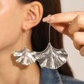 Detalle de pendientes de hoja de ginkgo plateados con textura cepillada en denim - Pendientes de Hojas de Ginkgo con Textura Plisada (8664) / Plateado