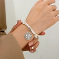 Detalle de pulsera de rosario con perlas blancas y medalla de San Benito en la muñeca - Rosario de Cuentas de Plata Antigua (03 plata antigua K-178)