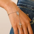 Pulsera rosario plateada con cruz y medalla de María llevada sobre fondo de mezclilla - Blanco K (02 blanco k 7300)