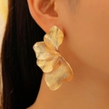 Golden leaf flower petal earring in textured finish worn by a model in a close-up view - Gold Pleated Process Style