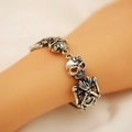 Gothic retro silver skeleton bracelet with skull pendants and bow details worn by model - Skull Bow Style (10813) / Ancient Silver (Bow Skull Bracelet)