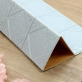 Dettaglio macro dell'adesivo murale 3D azzurro con motivo a rombi e trama floreale - Quadrato Bianco