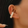 Detail of five glossy pearls on a striped silver ear cuff worn on the ear cartilage - 22 Pearl White 1881