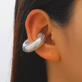 Close-up of a silver-colored textured ear cuff with threaded design on a female ear - 24 Bright Silver F-084