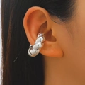 Macro shot of a silver twisted stripe ear cuff worn on the cartilage by a model - 25 Bright Silver Z-369