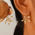 Close-up of golden orchid flower earrings with a matte metallic texture on ear - Abstract Petal Style (N-289) / Matte Gold