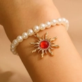 Bracciale di perle vintage con ciondolo a sole dorato e gemma rossa centrale incastonata - Bracciale Oro Rosso
