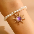 Bracciale retrò di perle con pendente a sole dorato e gemma viola incastonata - Bracciale Oro Viola
