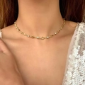 Gargantilla dorada con eslabones de corazón y circones sobre vestido de lentejuelas - Collar Corto Dorado