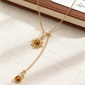 Detailed view of a gold Y-shaped necklace with sunburst and tiger eye stone pendants - Sunburst Y-Shape Style (8437)