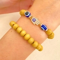 Dettaglio di bracciali a strati di perline gialle con ciondolo Mano di Fatima e Malocchio - Stile Mano di Fatima Malocchio / Set da 2 pezzi / Combinazione Occhio Giallo Oro (04)