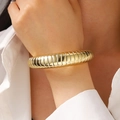 Irregular gold pleated cuff bracelet with chunky texture and glossy metallic finish - Threaded Bangle (11431) / KC Gold