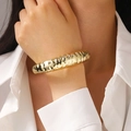 Detailopname van de gouden chunky armband met onregelmatige gegolfde textuur - Gehamerde Armband (7806) / KC Goud