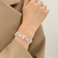 Primer plano de una pulsera tejida plateada con pedrería en la muñeca para eventos de gala - Estilo Trenzado con Strass Completo (K-1535) / Plata Brillante