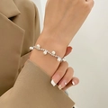 Primer plano de pulsera plateada de pedrería con perlas en la muñeca de una modelo - Estilo de Cadena Fina con Perlas (K-1536) / Plata Brillante