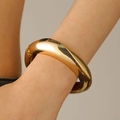 Polished thick gold geometric spring open bangle showing reflective mirror metal finish - Smooth Chunky Bangle (9498) / KC Gold