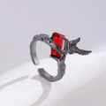Macro shot of gothic style open ring with red gem and intricate metal wing texture - Raven Claw Square Zirconia Style (7523)