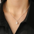Detailed close-up of a silver shell pendant with a white pearl on a delicate chain - Bright Silver 0099 Shell Wrapped Pearl Style