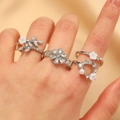 Elegante vierdelige zilveren ringenset met witte bloembedels en kunstparels - Zilver