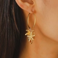 Orecchini dorati serie oceano con stella marina e conchiglie indossati da modella - Stile a Cerchio Pendente Vita Marina (9814) / Oro Opaco