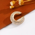 Vista macro di un earcuff dorato a forma di C con zirconi scintillanti su fondo in pelle - Oro (Singolo-1.9cm)