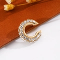 Dettaglio ravvicinato dell'orecchino a cerchio C placcato oro con strass su velluto marrone - Oro (Singolo-1.3cm)