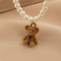 Macro del ciondolo a forma di orsetto marrone peluche e collana di perle su tessuto - Collana di Perle Artificiali Orsetto Marrone (5616)