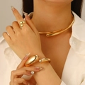 Golden minimalist jewelry set featuring a wide bangle, teardrop ring, and collar necklace - Large Bangle Three Piece Set / Gold