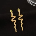 Dettaglio macro di orecchini a serpente dorati con zirconi pavé e pietre verdi negli occhi - Pendente a Serpente a S Intarsiato (10154)