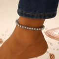 Glinsterende zilveren enkelband met zirkonia en strass-steentjes gedragen op een zandstrand - Zilveren Enkelbandje (2407)