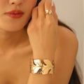 Detail of gold leaf hollow pattern ring and cuff bracelet on female model wrist - Golden Hollow Leaf Bracelet And Ring Set (10)