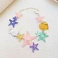 Dettaglio di ciondoli a stella marina e conchiglia con perle e chiusura a moschettone - Bracciale Stella Marina Conchiglia Multicolore (12428)