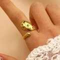 Détail d'une bague géométrique dorée avec zircons multicolores sur un doigt - Style Ouvert Incrusté Multicolore (7074)