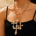 Detail of layered gold necklaces with pearl and colorful gemstone cross pendants on model - Gold Jewelry Set (18)