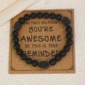 Bracelet à perles noires mates avec pierres de lave présenté sur une carte cadeau - 14 Noir (2594)