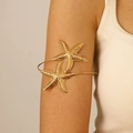 Détail d'un bracelet de bras étoile de mer dorée bohème avec surface texturée sur le mannequin - Or KC 7910