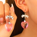 Sweet silver bow earrings with translucent pink heart pendants on model - Pink Transparent Heart Silver Bowknot Style (N-058)
