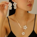 Détail d'une parure élégante à fleurs blanches avec chaîne serpent dorée et fermoir en T - Collier Et Boucles d'oreilles Blancs