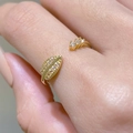 Adjustable golden leaf ring featuring cubic zirconia stones on model hand - Leaf Pattern (35030342) / Adjustable / Gold
