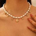 Detail of bohemian pearl necklace featuring gold starfish and seashell charms on model - Marine Shell Starfish Pearl Necklace(2406)